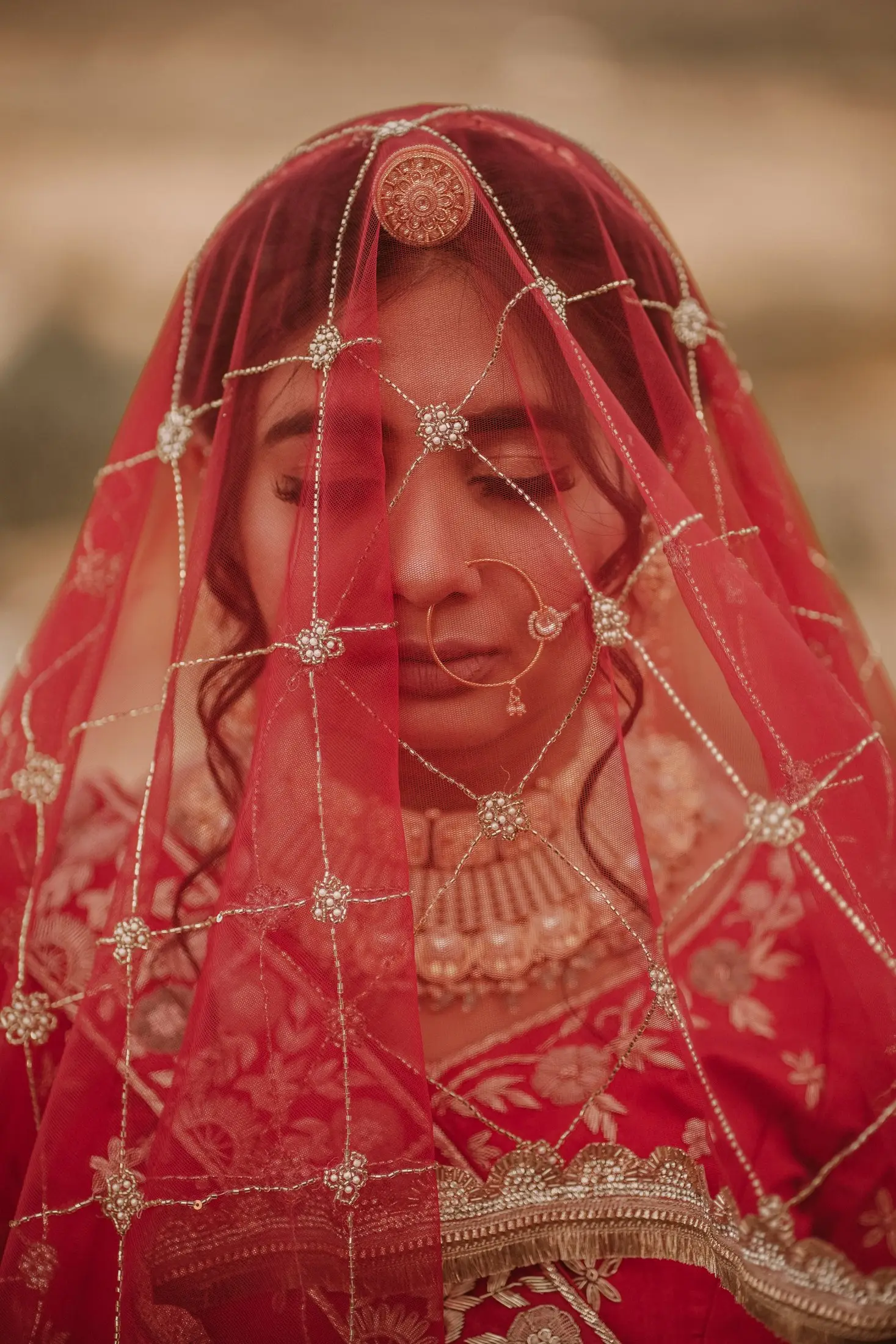 Bride in a red embroidered veil with traditional jewellery